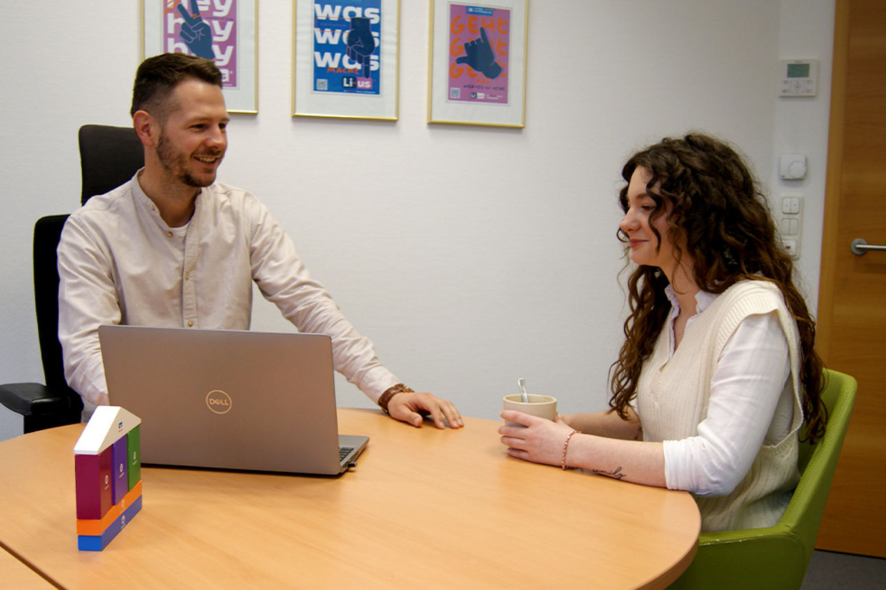 Kundenberater führt mit einer Kundin die Genossenschaftliche Beratung durch.