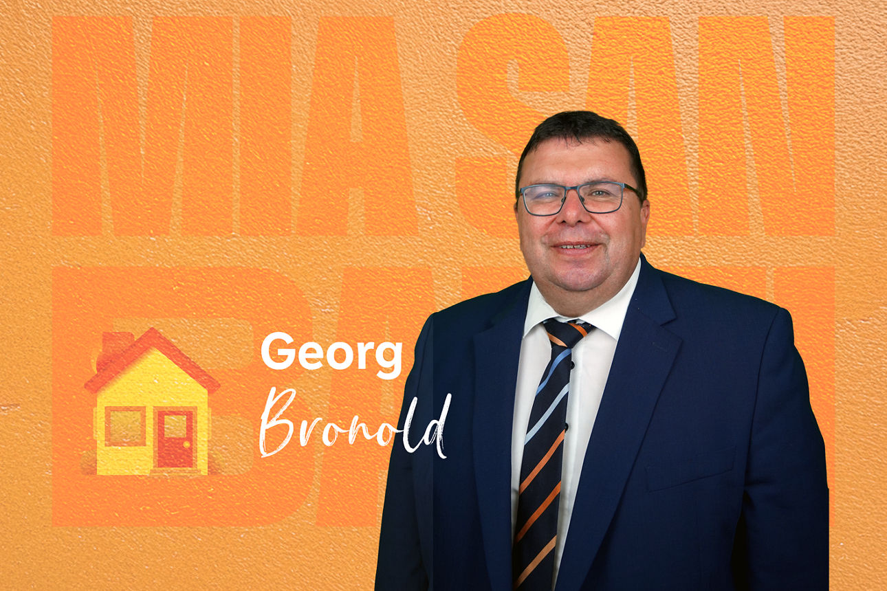 Das Bild zeigt einen Mann vor einem orangen Hintergrund mit weißen Text "Georg Bronold"