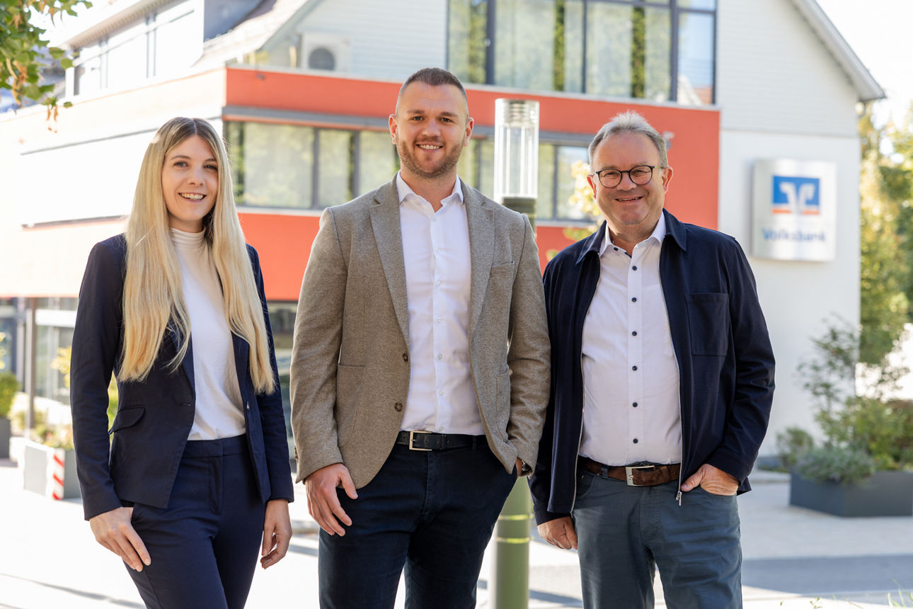 Mitarbeiter R+V Versicherung Katja Gerlach, Luca Keller und Helmut Maier vor Bankgebäude