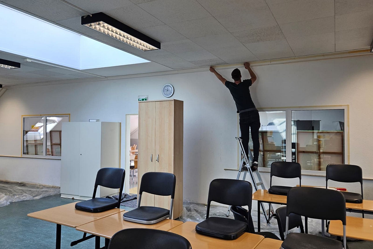 In einem Dachgeschossraum der Gesamtschule Schermbeck wird der Boden abgedeckt. Andrea Freitag arbeitet gerade an den Heizkörpern.