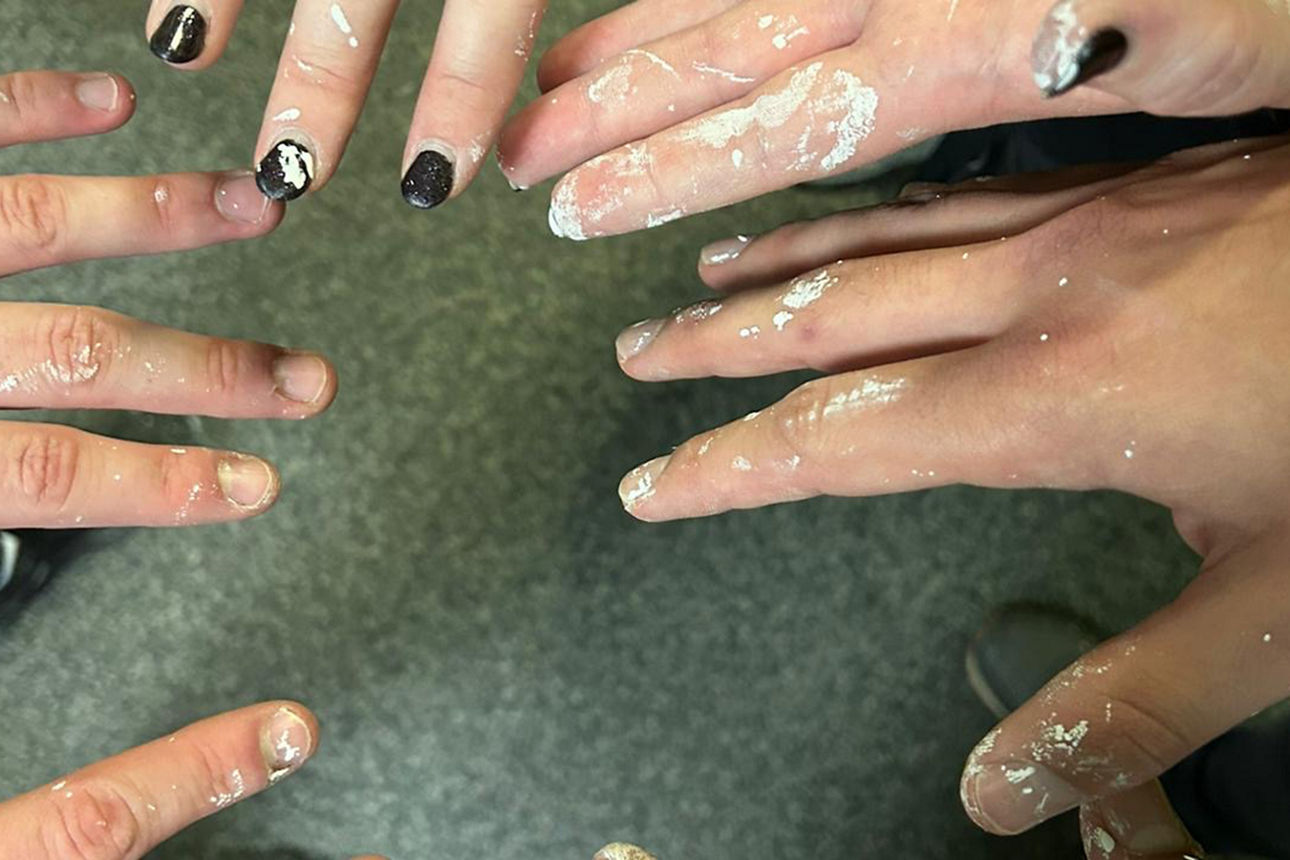 Fünf Hände mit weißen Farbflecken.