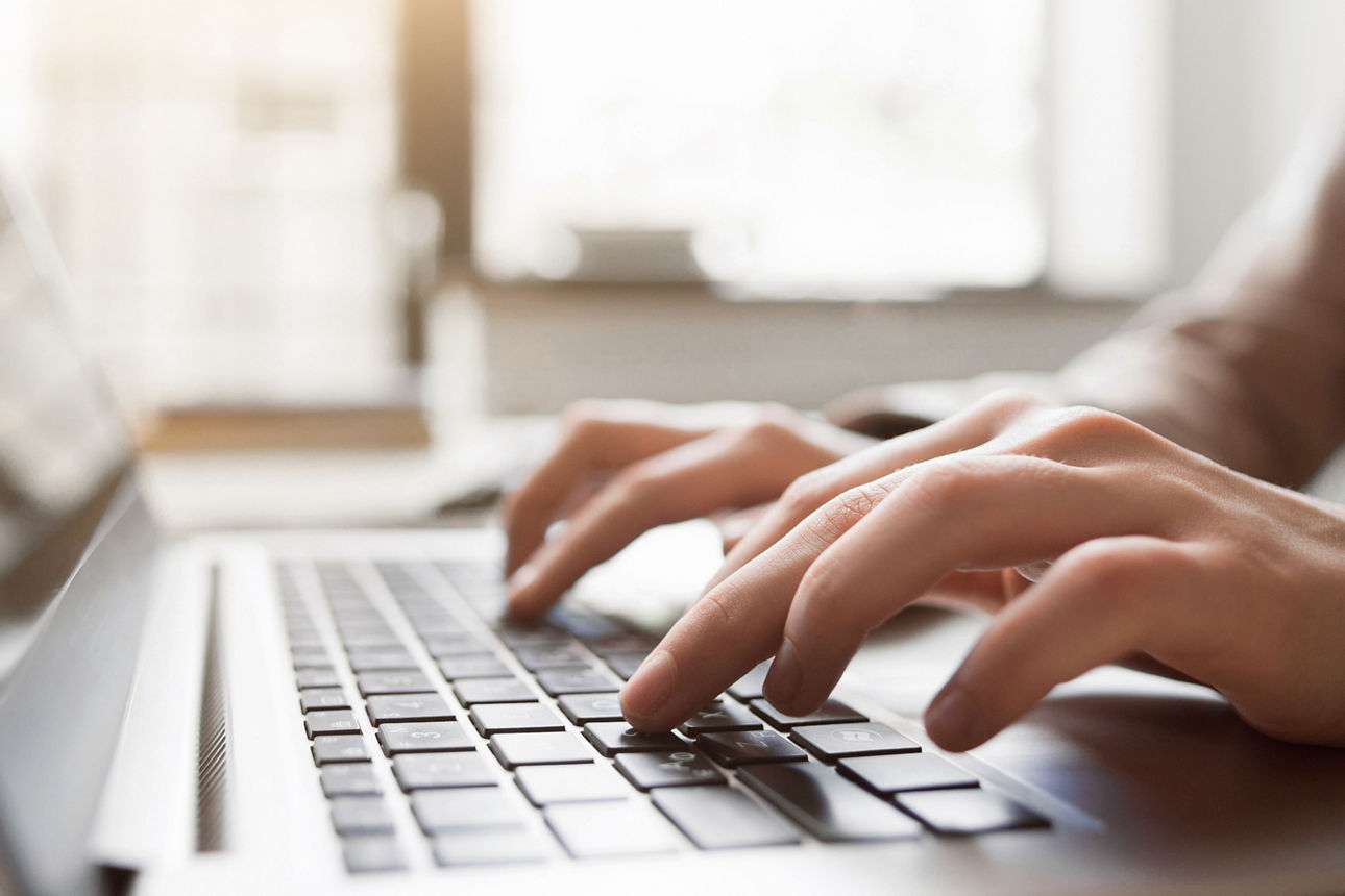 Nahaufnahme von Händen, die an einem PC arbeiten.