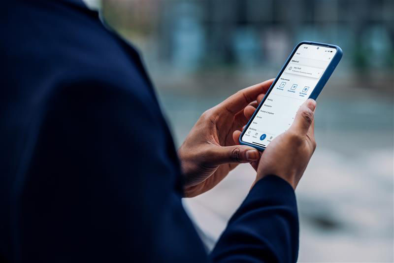 Mann mit einem Handy in der Hand, mit der BBBank Banking App auf dem Screen.