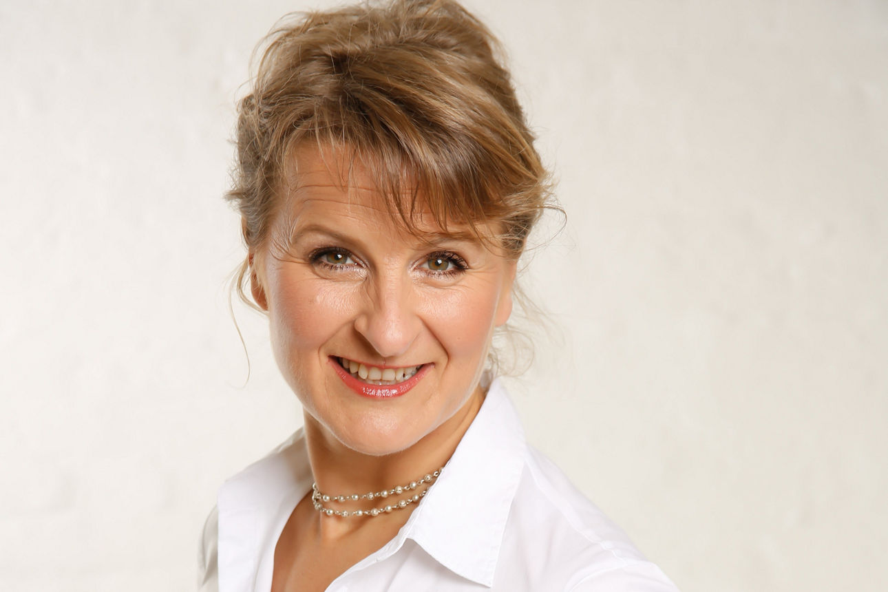 Eine Frau  lächelt in die Kamera