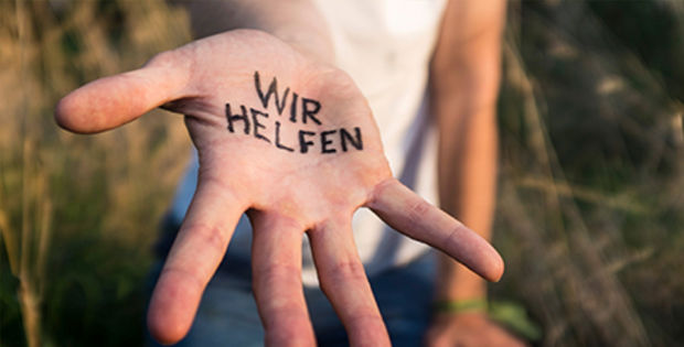 Mensch in der Natur mit der Aufschrift "Wir helfen" in der Handinnnefläche