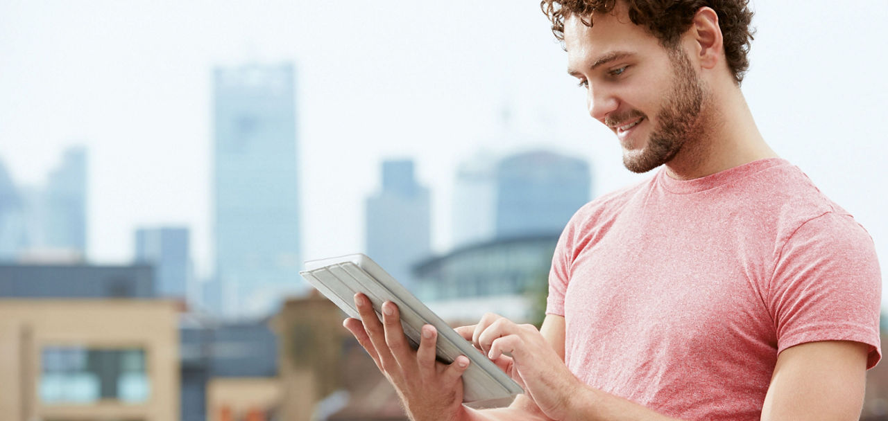 Mann schaut auf ein Tablet in seiner Hand