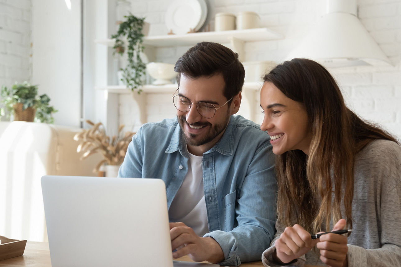Junges Paar sitzt vor einem Laptop