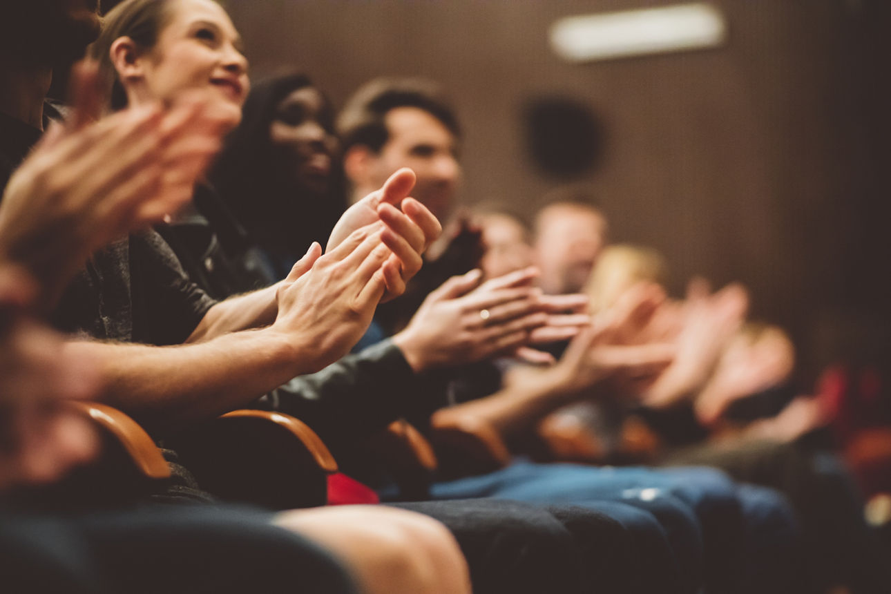Gruppe lächelnder Menschen Menschen in einem Theater, die applaudieren