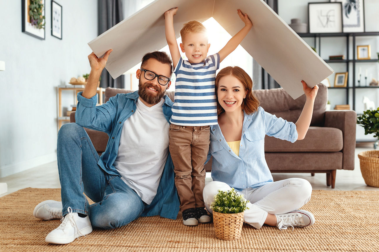 Familie unter einem Dach aus Karton