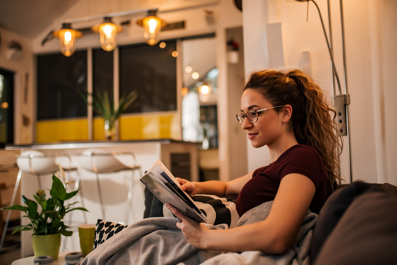 Frau sitzt auf Couch und liest