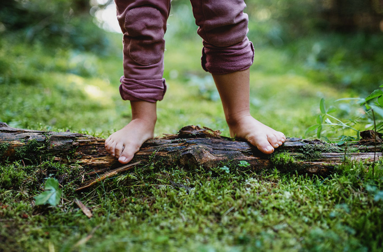 nackte Kinderfüße auf Waldboden