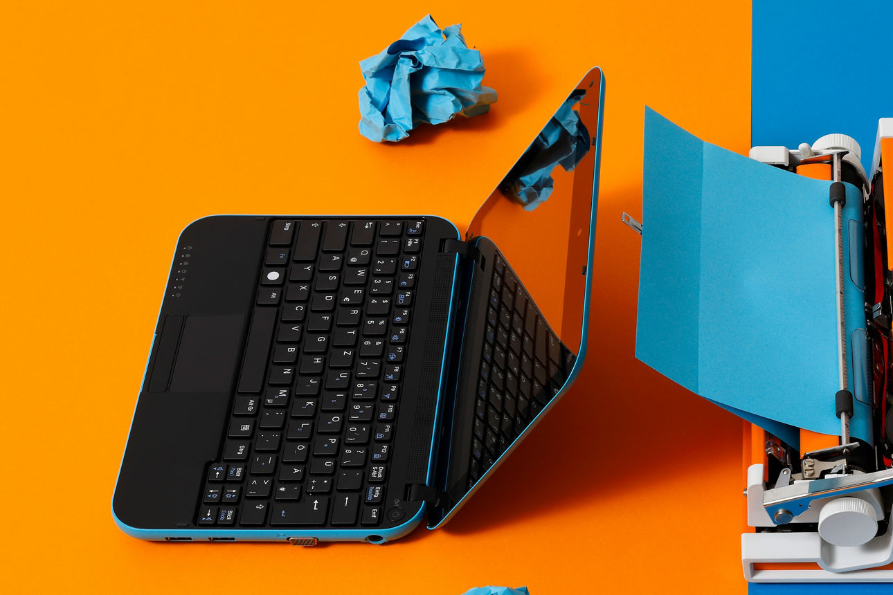 Zwei Generationen treffen sich – moderner Laptop und 70er-Schreibmaschine