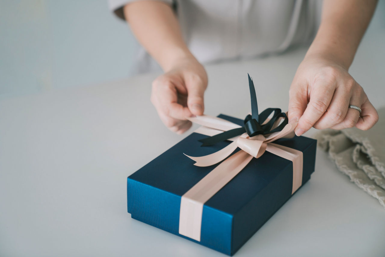 adult woman receiving and opening gift at home