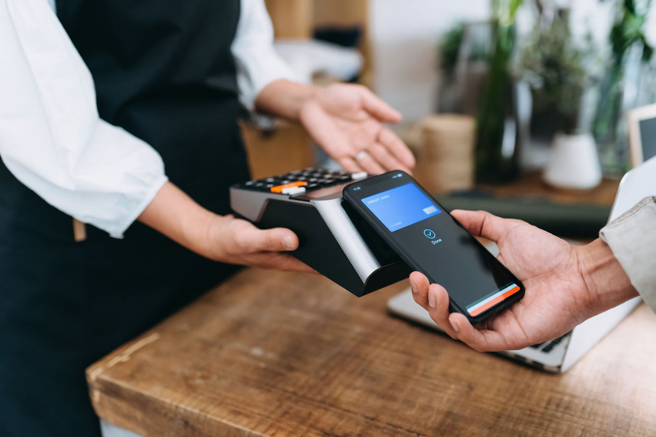 Bezahlung mit dem Handy an einem Kartenterminal im Geschäft