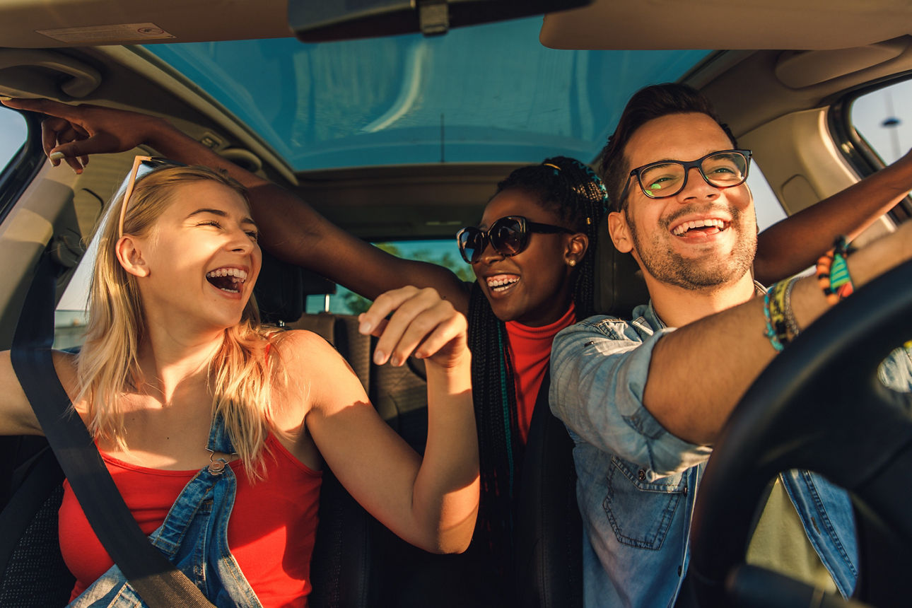 Drei junge Menschen fahren gemeinsam im Auto
