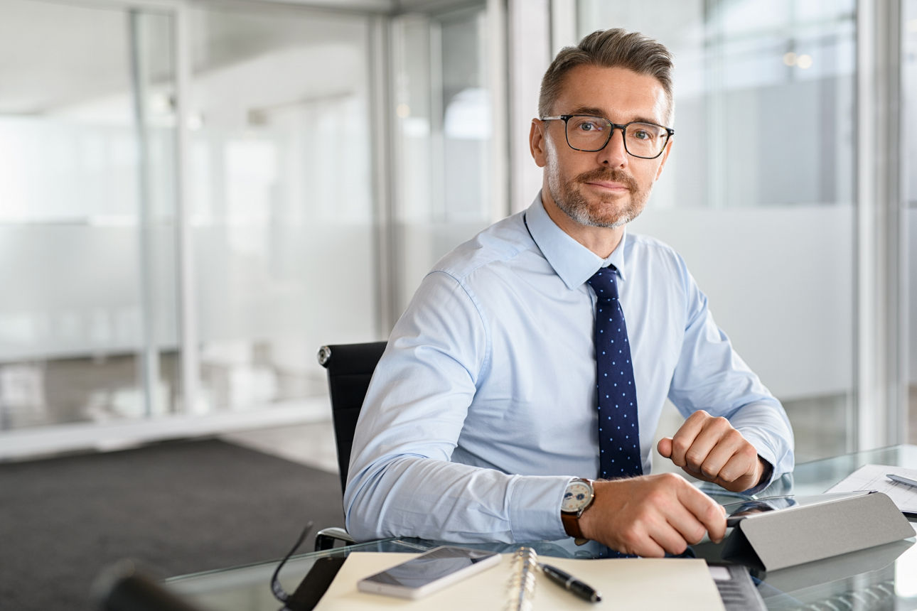 Portrait of mature businessman using digital tablet at work. 