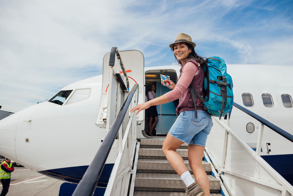 Junge Frau steigt in Flugzeug ein