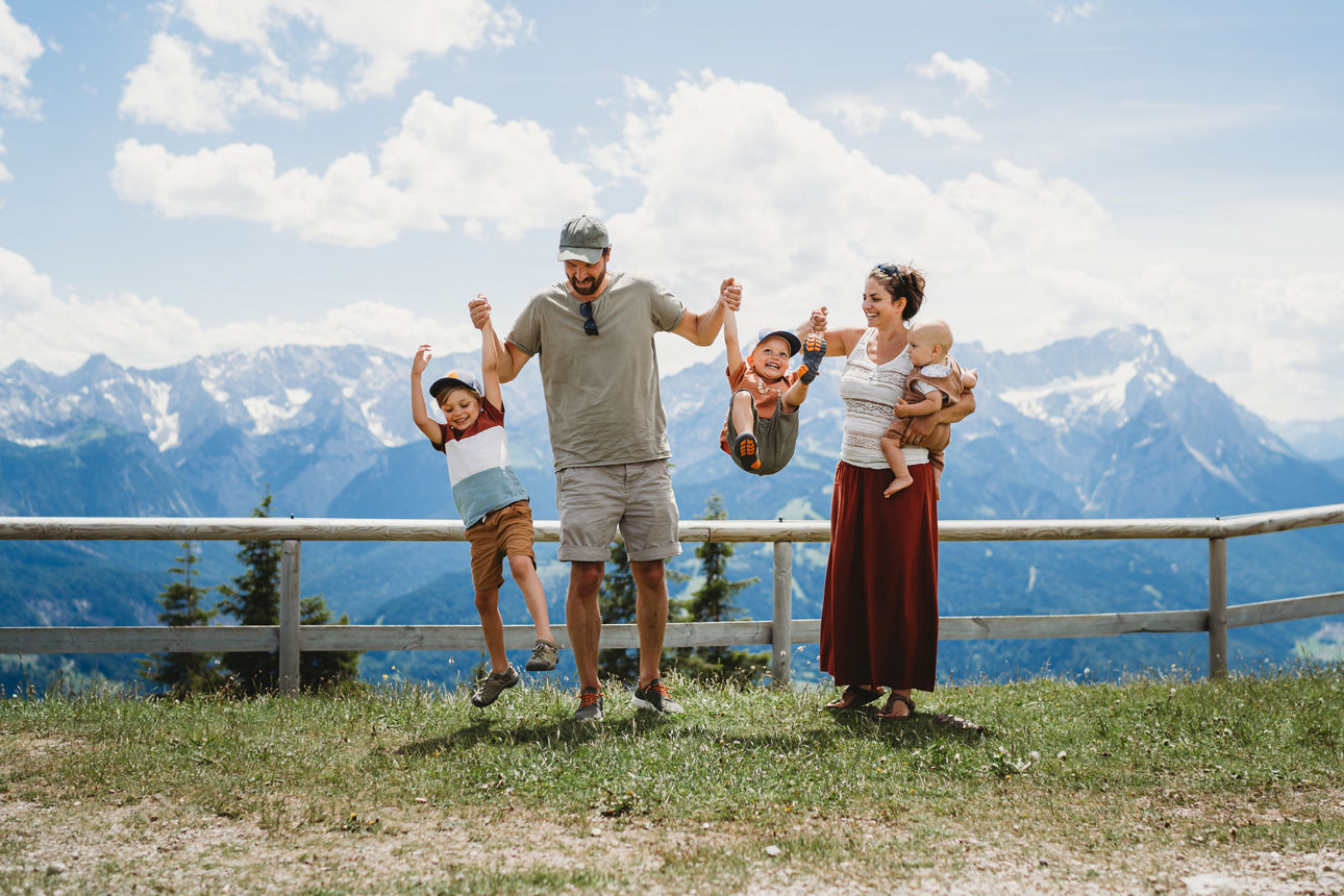 Eine Familie mit zwei Kindern vor einer Berglandschaft