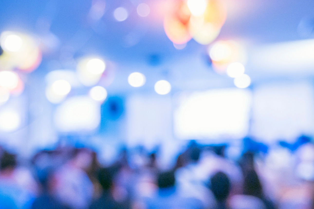 Menschen mit verschwommenem Hintergrund nehmen an einer Seminar-Geschäftsveranstaltung in der Auditoriumshalle teil