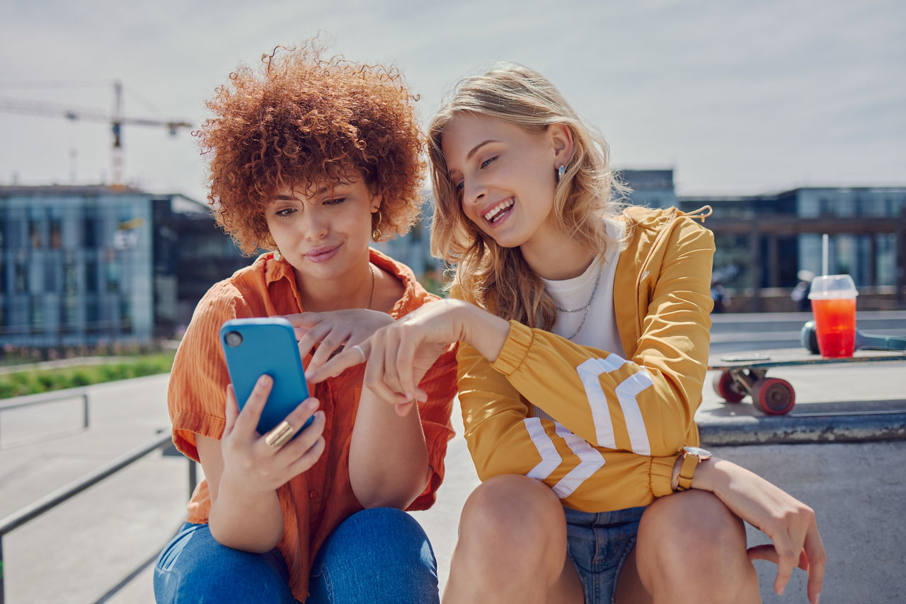 Zwei Frauen schauen die News auf dem Handy