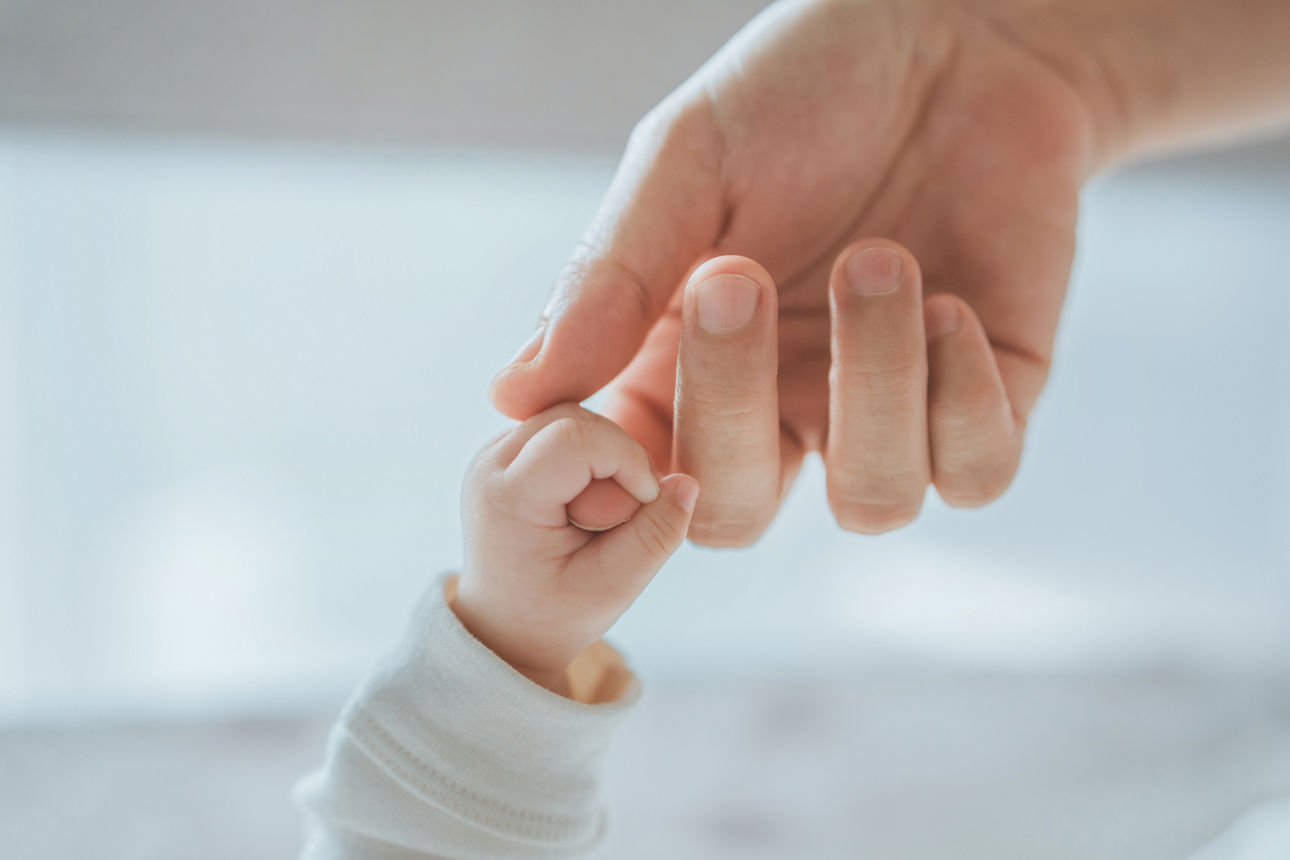 Hände die sich berühren Erwachsener und Baby