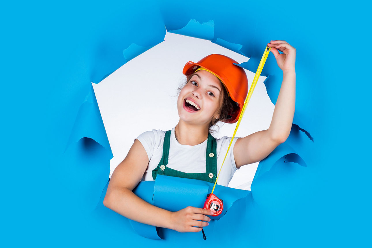 I need help. Little girl using a measuring tape. engineer. happy child hold tape measure. kid builder wear helmet. teen girl in hard hat and uniform. building and construction. concept of repair.