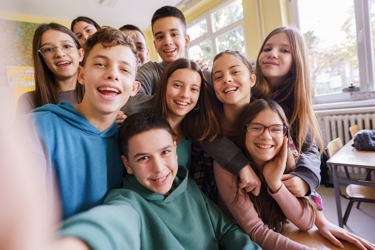 Mehrere Schülerinnen und Schüler machen ein Selfie im Klassenraum