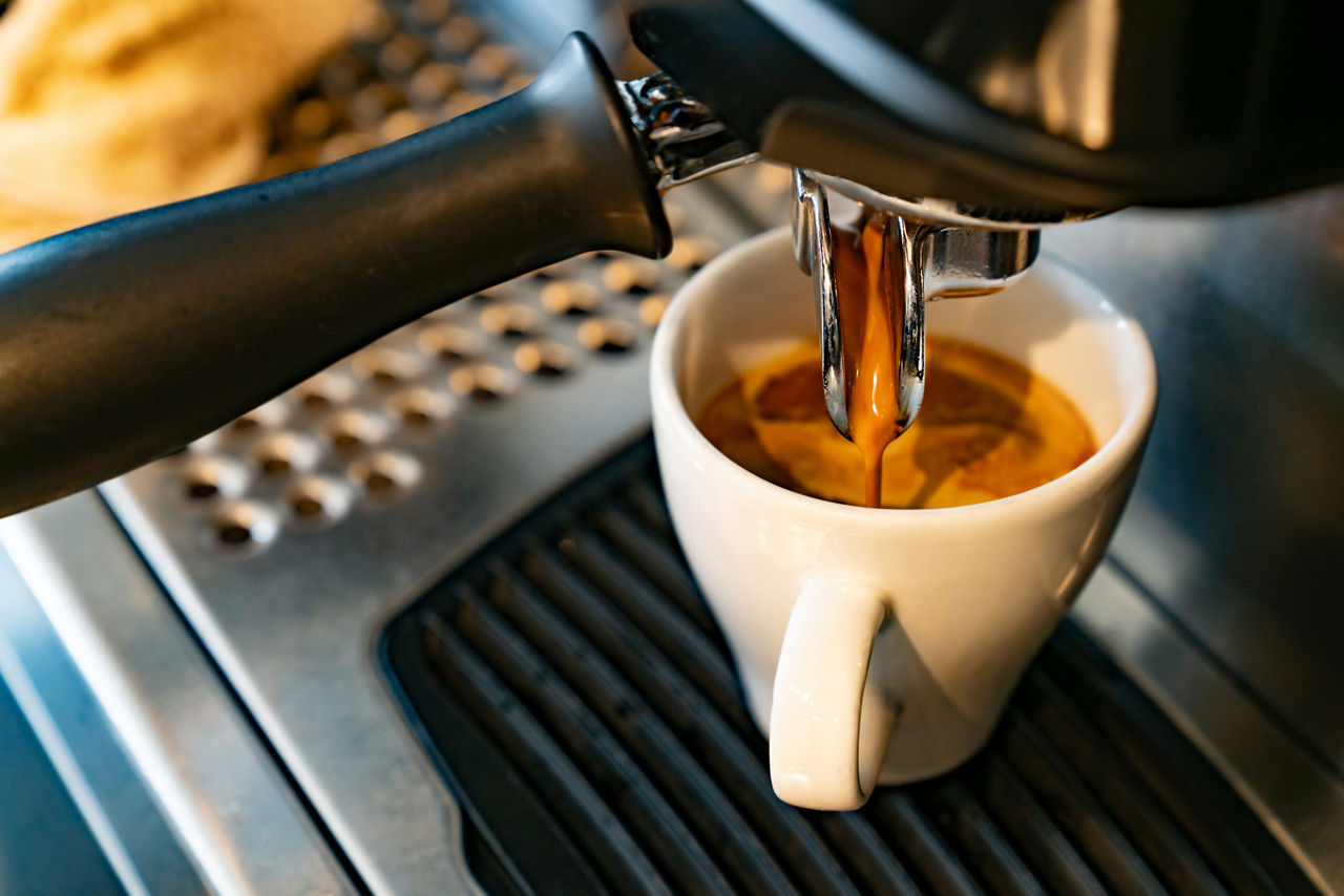 Close-up on a coffee maker making a espresso at a cafe - food and drink concepts