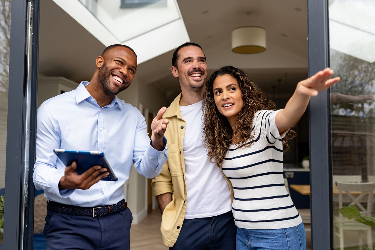 Zwei Männer und eine Frau stehen am Fenster und schauen gemeinsam nach drau´ßen
