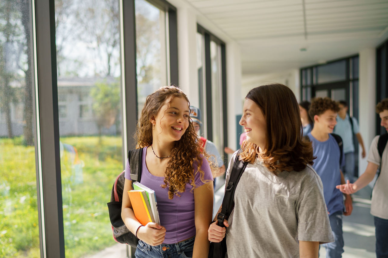 Zwei Schülerinnen unterhalten sich in der Schulpause
