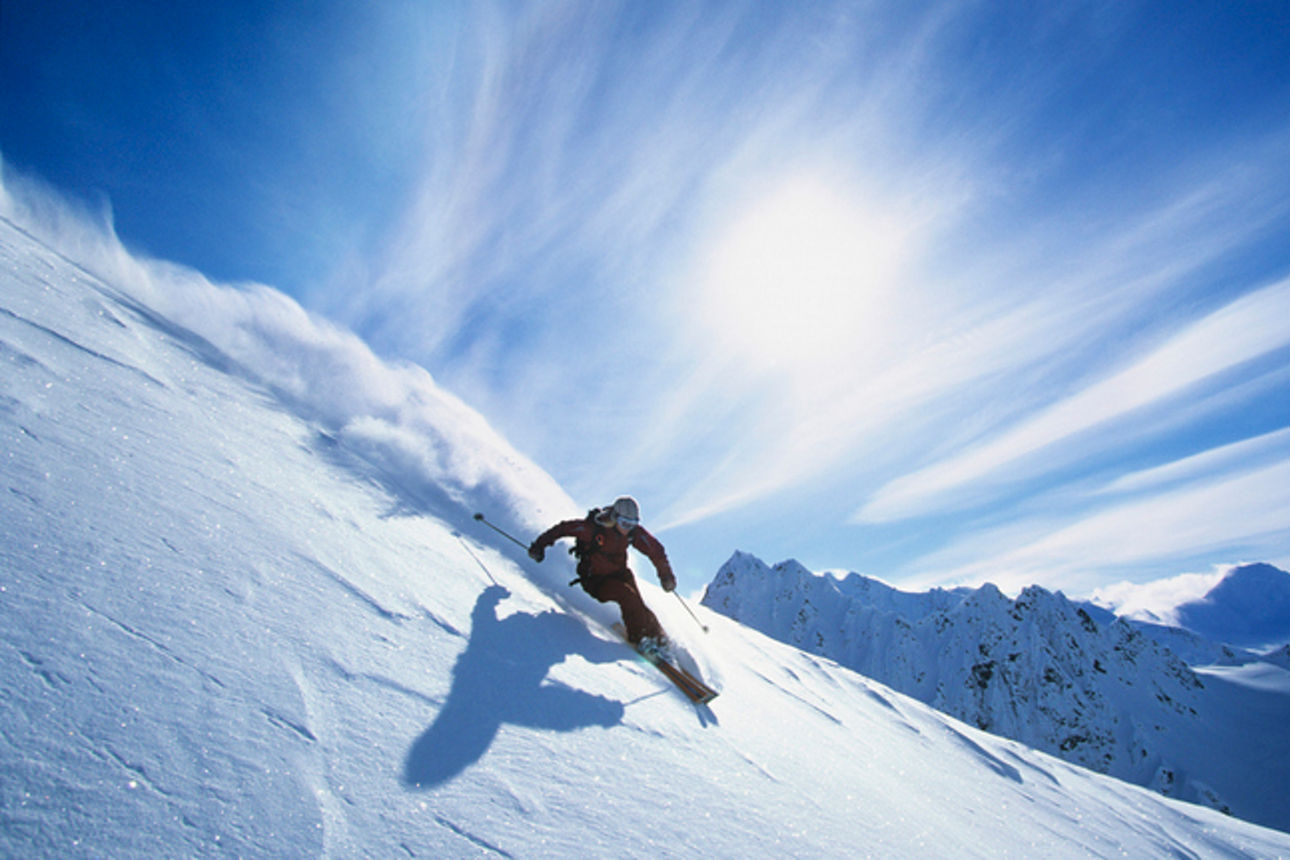 Full length of skier skiing on fresh powder snow