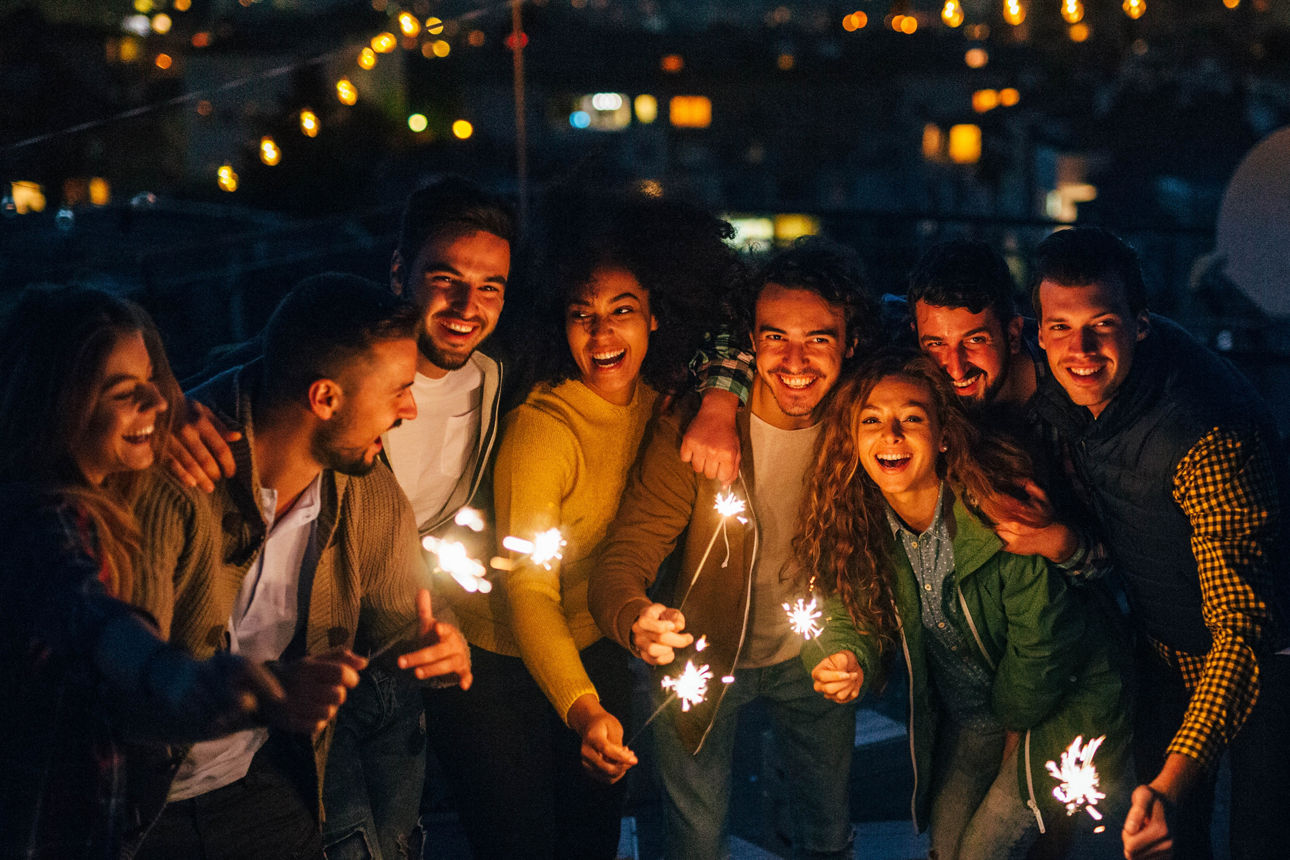 Gruppe feiernder Menschen mit Wunderkerzen in der Hand