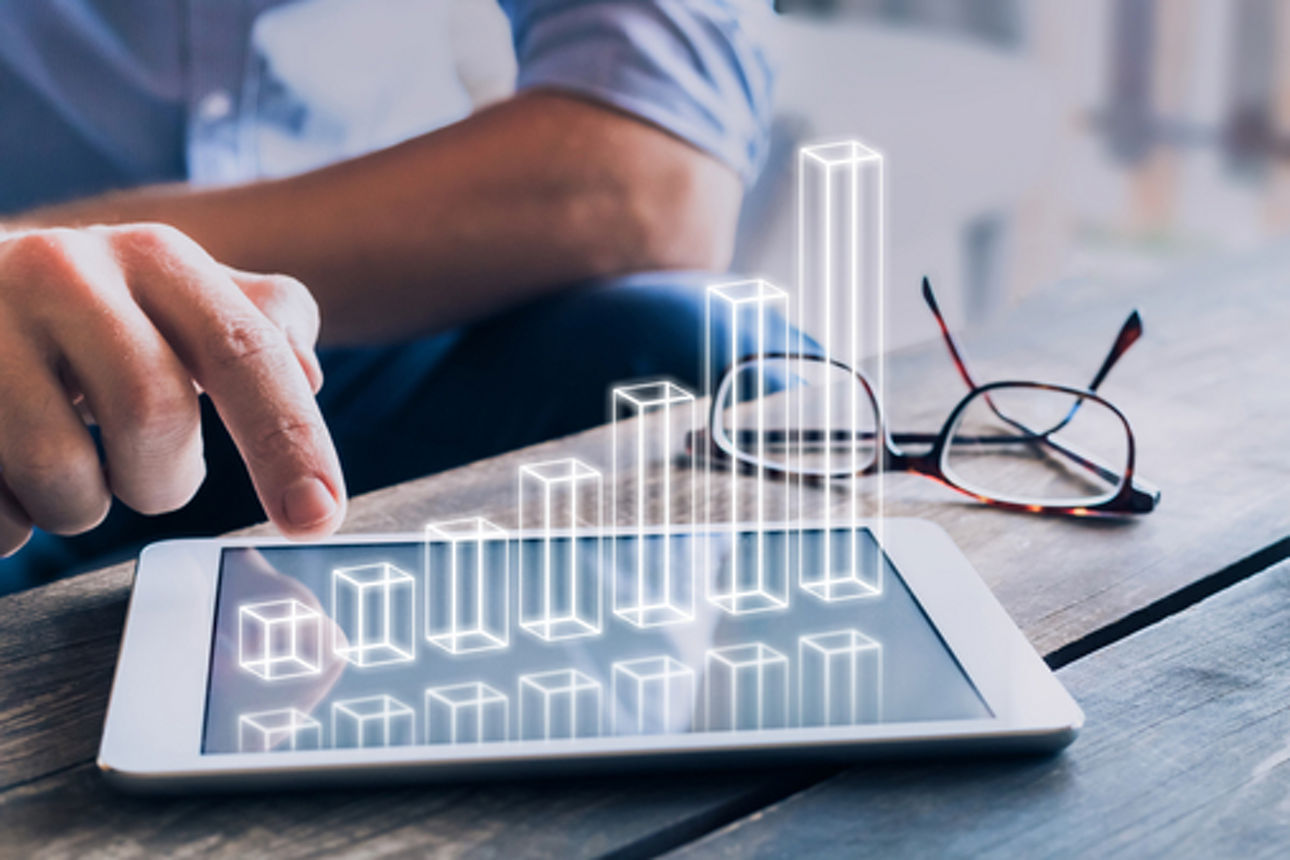 Businessman analyzing growing 3D AR chart floating above digital tablet computer screen, showing successful increase in business profit