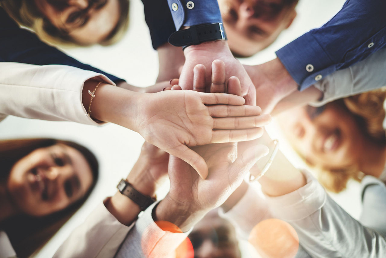 A group of young people putting their hands together