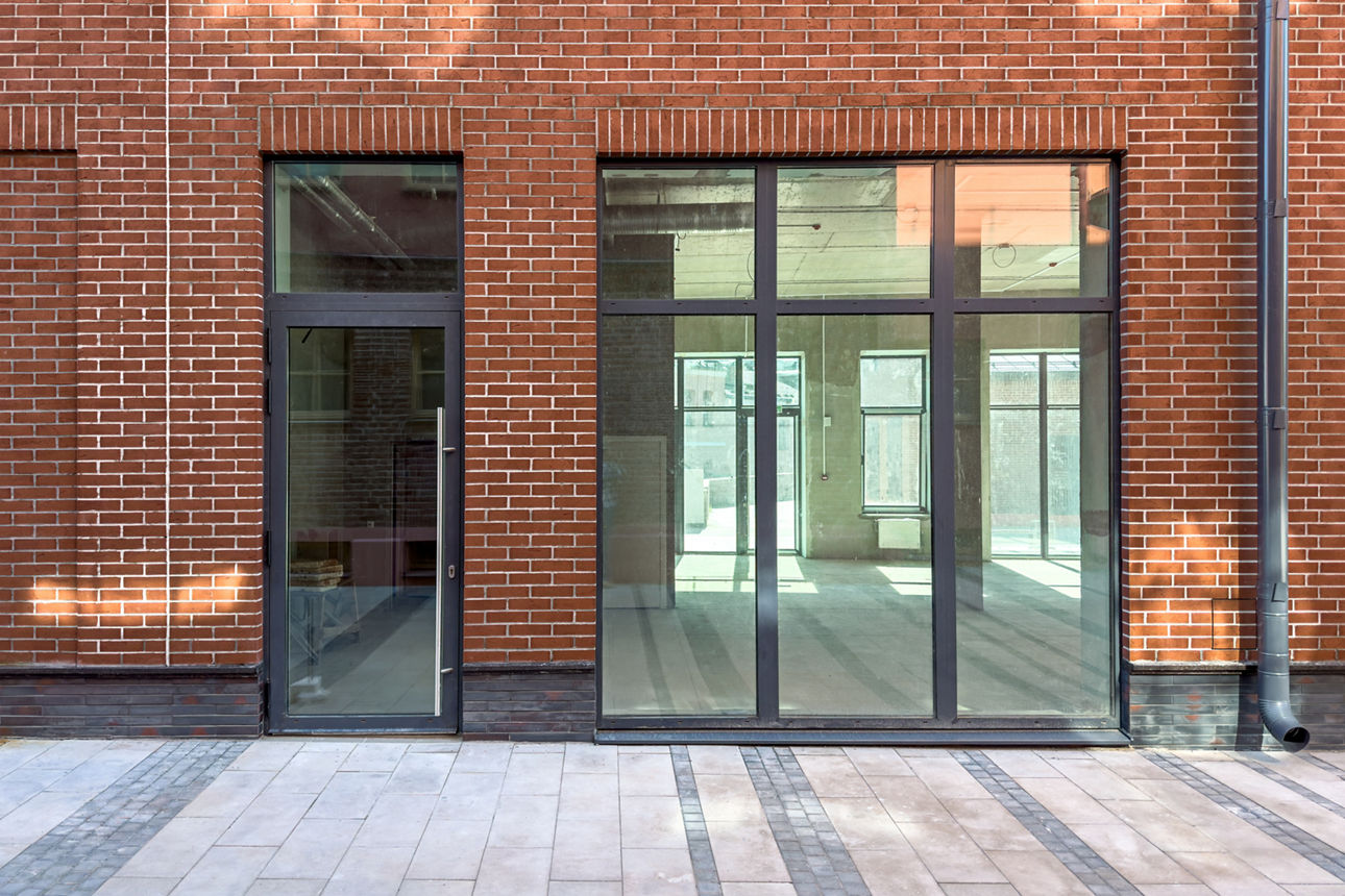 Die Außenwand eines traditionellen Gebäudes mit hoher, moderner Fensterfront.