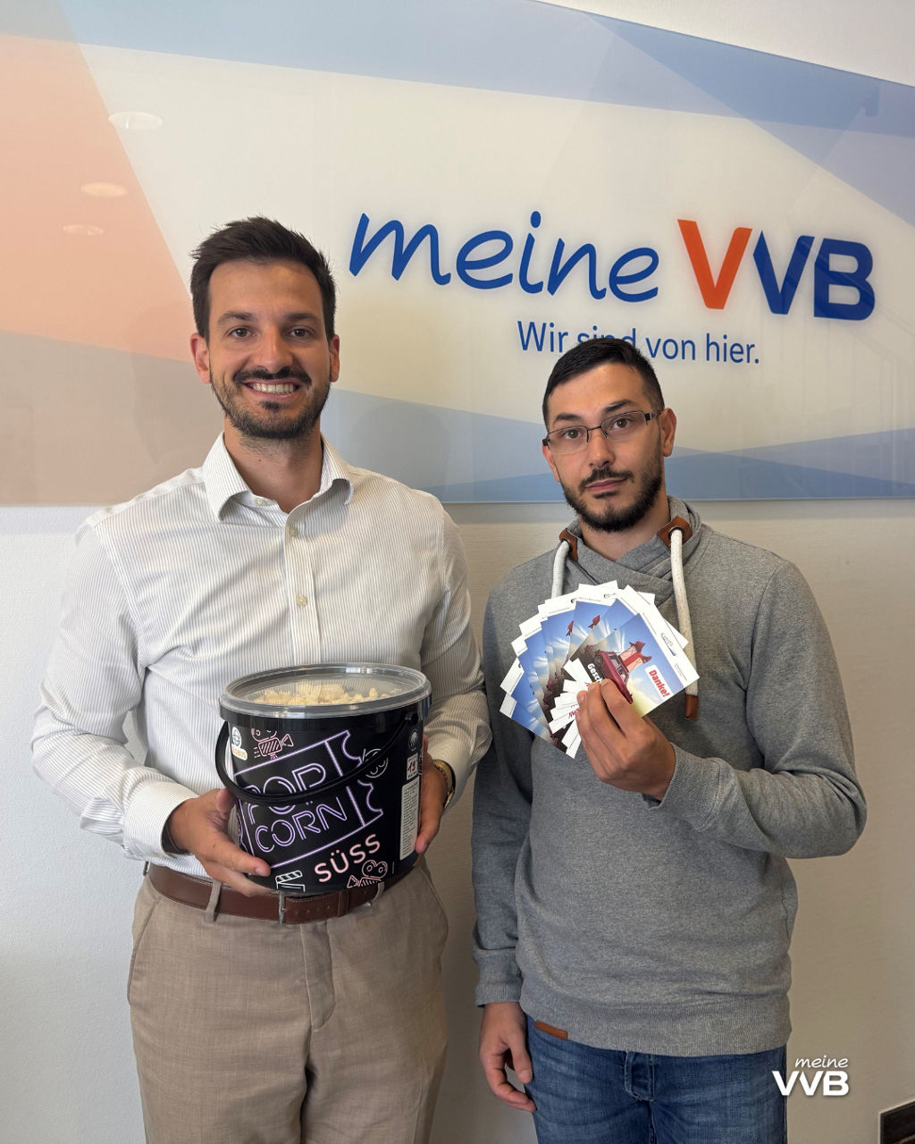 Zwei Männer mit Popcorn und Gutscheinen
