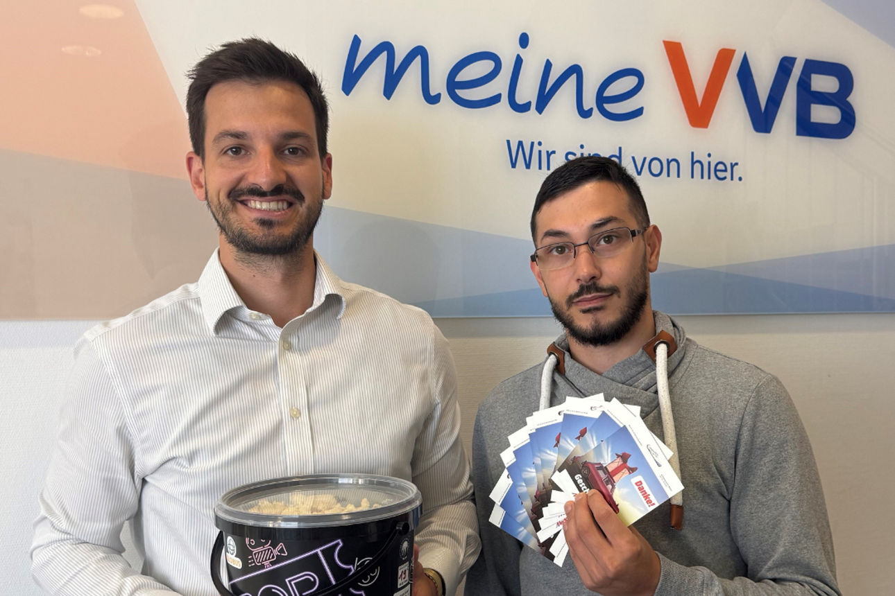 Zwei Männer mit Popcorn und Gutscheinen