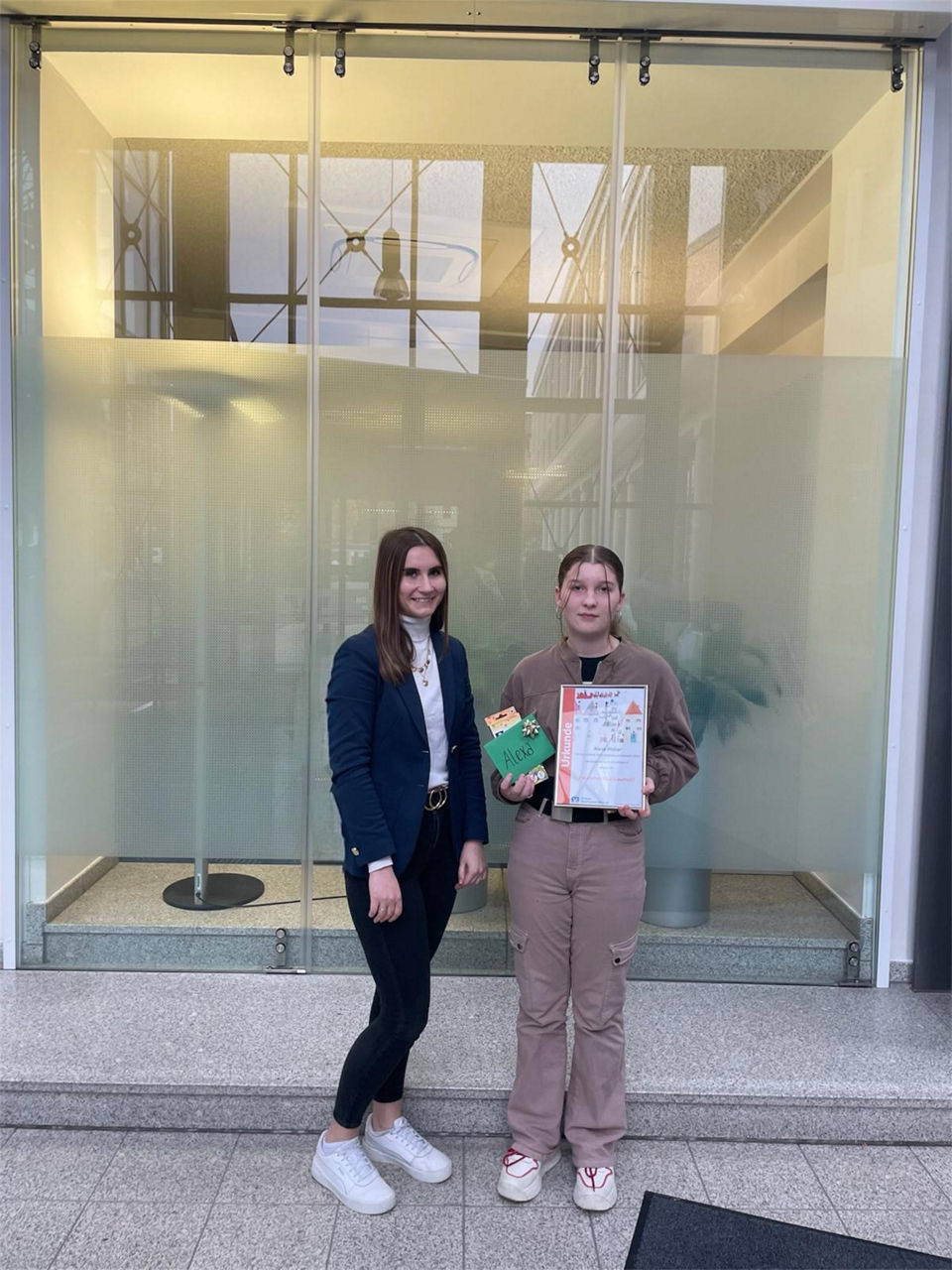 Beraterin übergibt Preis an Siegerin Weihnachtsmalwettbewerb