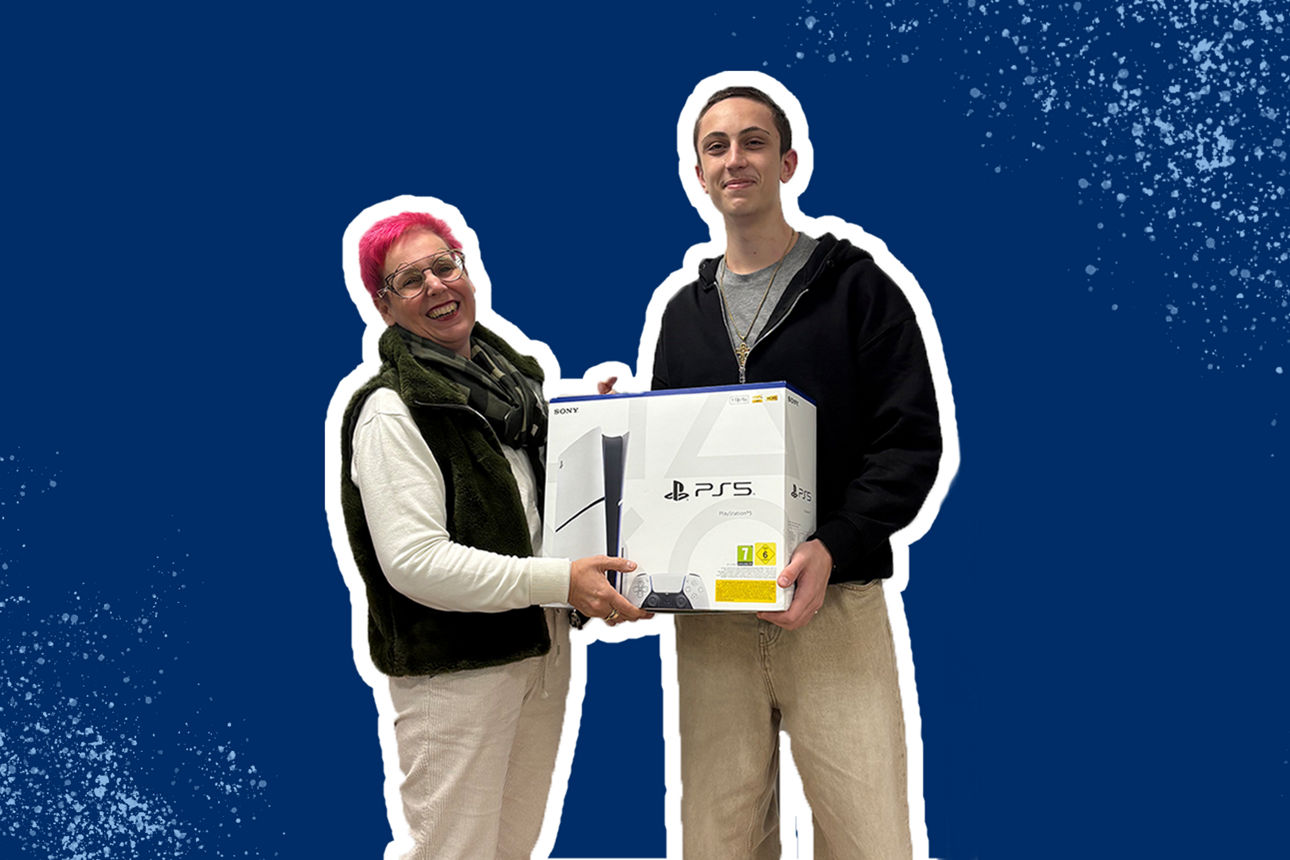 Zwei Personen stehen lächelnd nebeneinander und halten gemeinsam eine PlayStation 5-Konsole