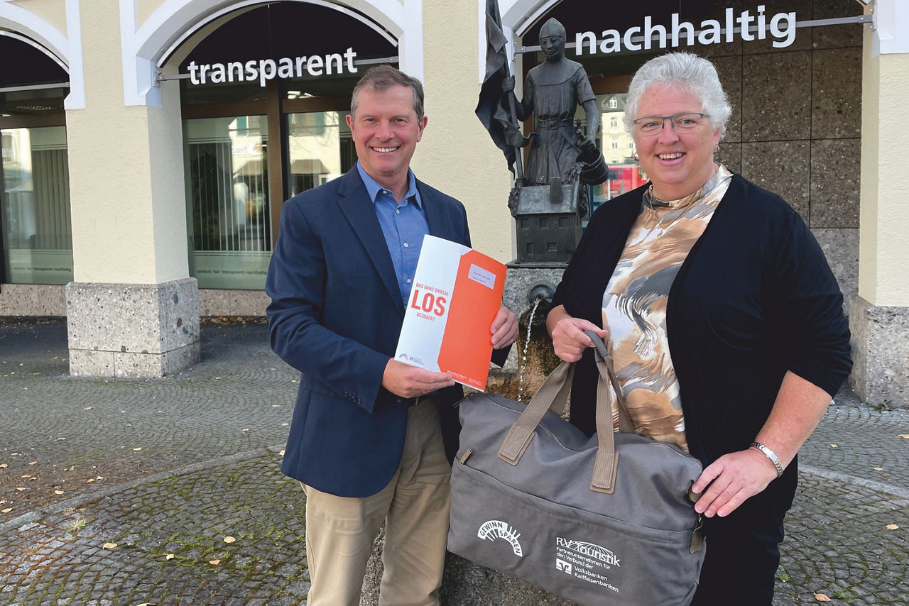Herr Thalhammer übergibt den Gutschein an die Gewinnerin