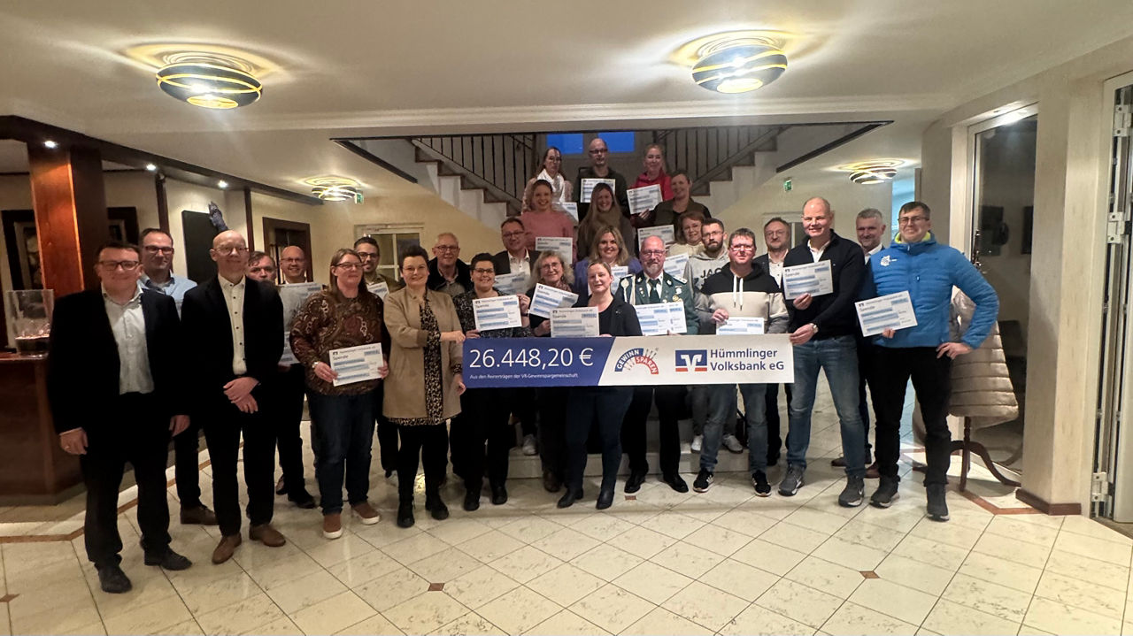 Eine Gruppe von Personen mit einem Plakat und vielen Schecks.