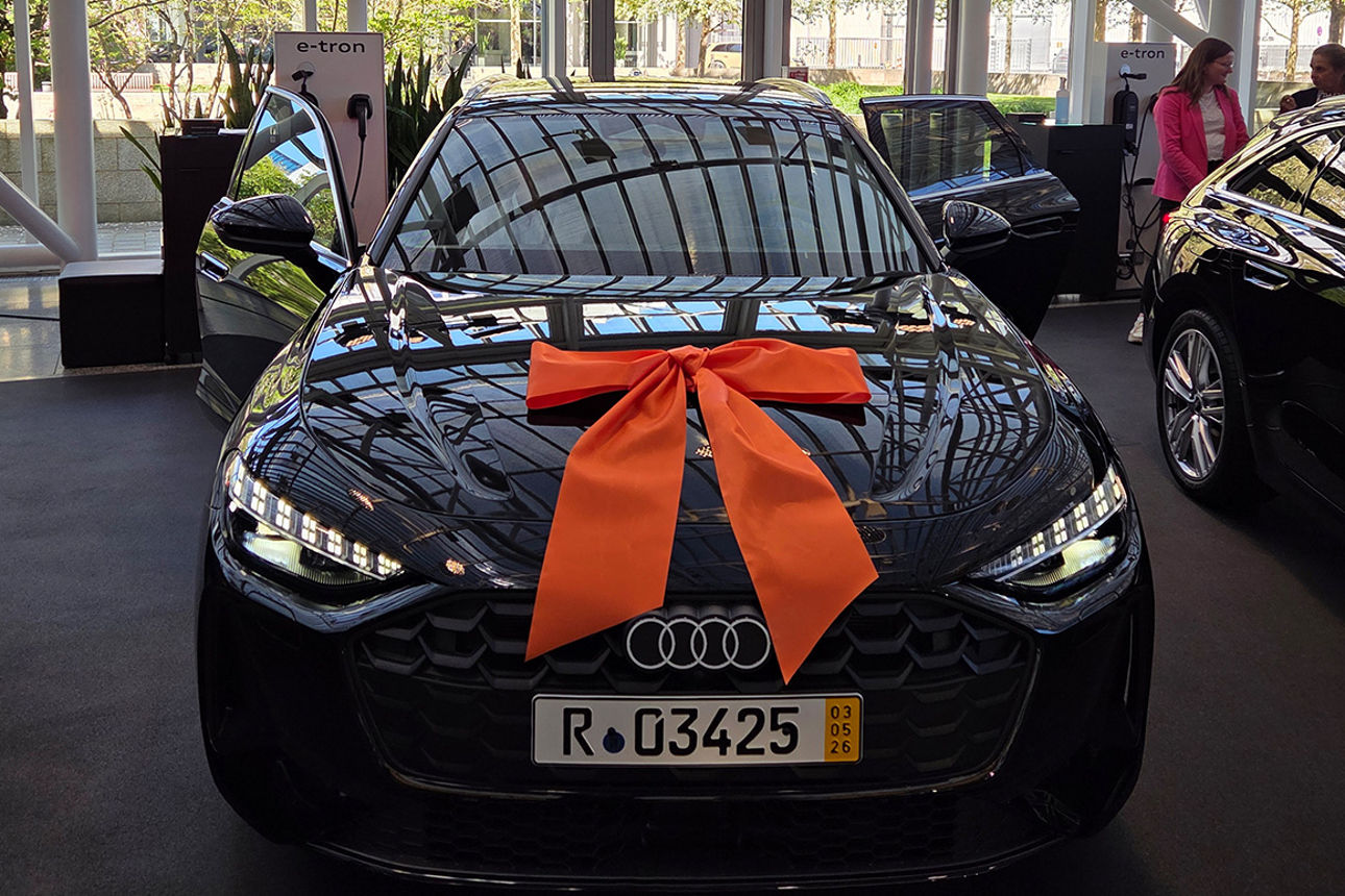 Ein schwarzes Auto mit einer orangen Schleife auf der Motorhaube