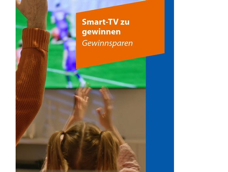 Vor einem Fernseher, der ein Fußballspiel zeigt, recken Menschen die Arme jubelnd in die Höhe