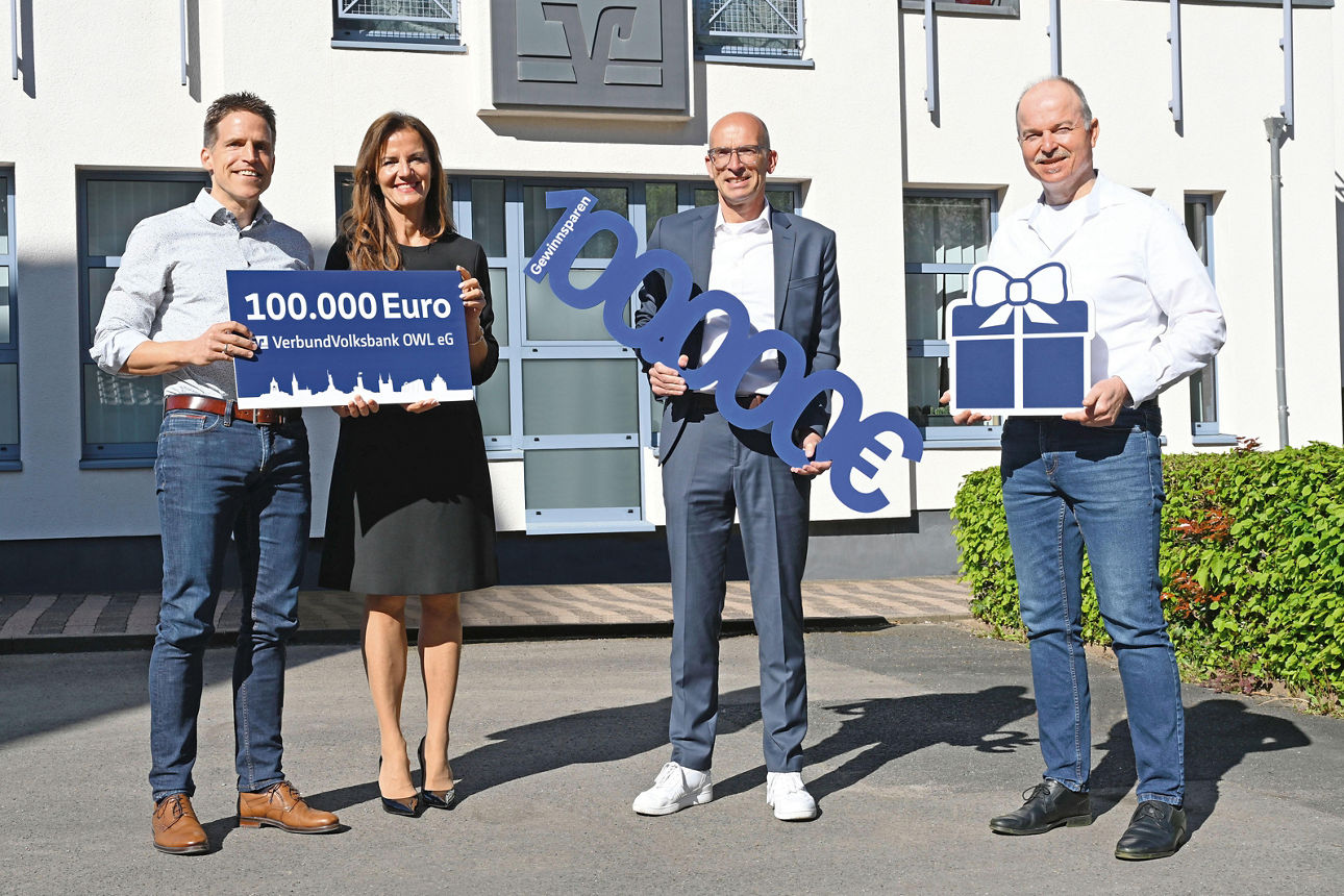 Vier Personen stehen lächelnd vor der Filiale Stahle der Volksbank Höxter und halten gemeinsam einen symbolischen Scheck über 100.000 Euro in den Händen und präsentieren damit die Gewinnübergabe des Gewinnsparvereins.