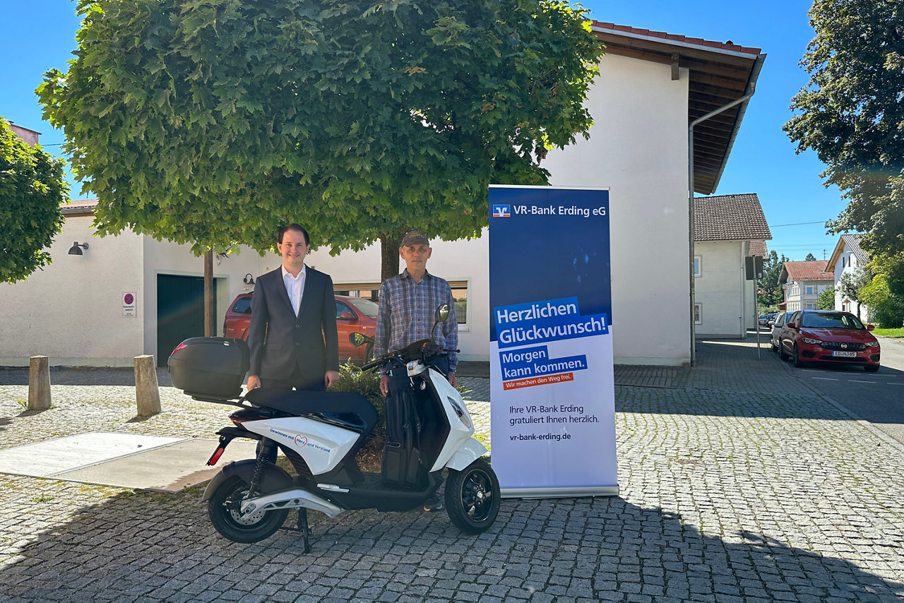 Kunde Josef Roth und Berater Florian Mayer bei der Übergabe des E-Rollers