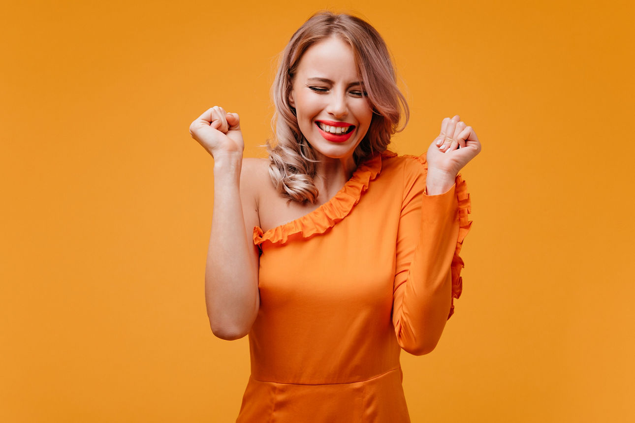 Ein Bild mit einer Frau, die sich freut und glücklich aussieht.