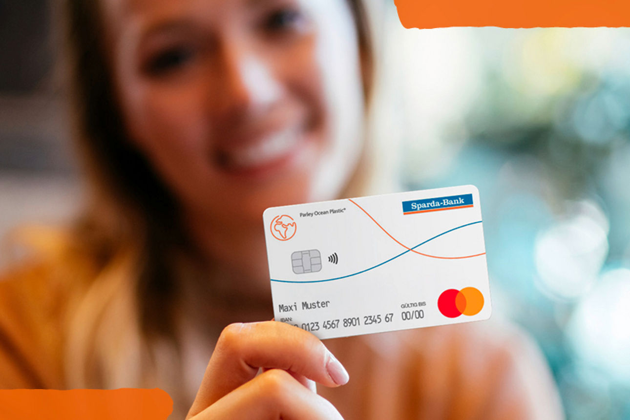 Frau hält Girocard in die Kamera