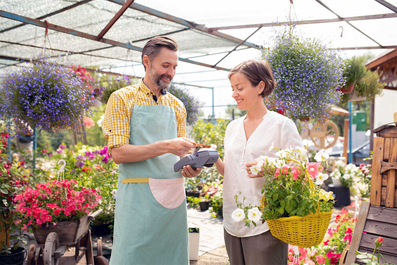 Frau bezahlt im Blumengeschäft mit Karte