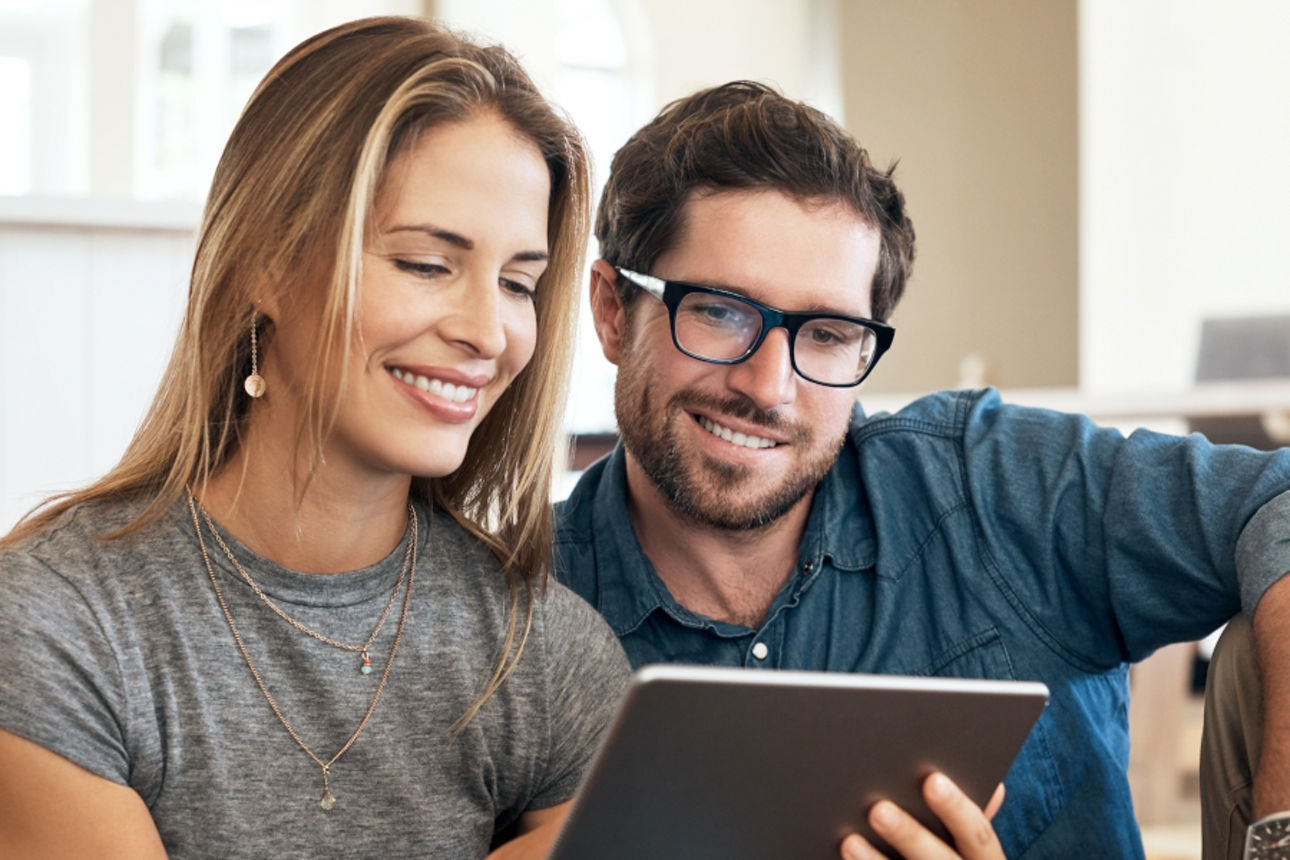 Junges Paar in ihrer Wohnung schauen auf ein Tablett