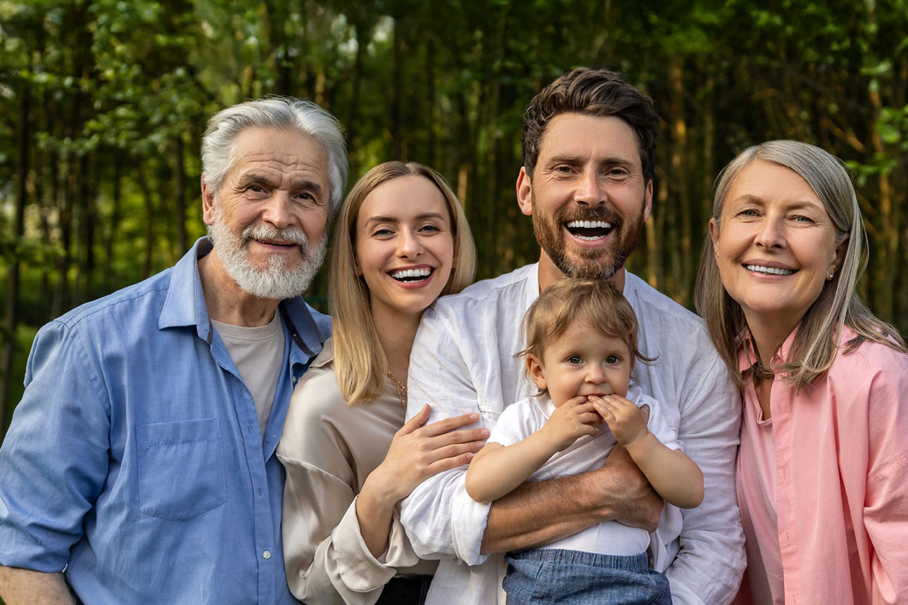 Junge Familie mit Kind auf dem Arm und dem Großvater daneben